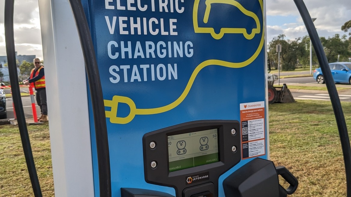 Electric vehicle charging station with two hoses and a small screen